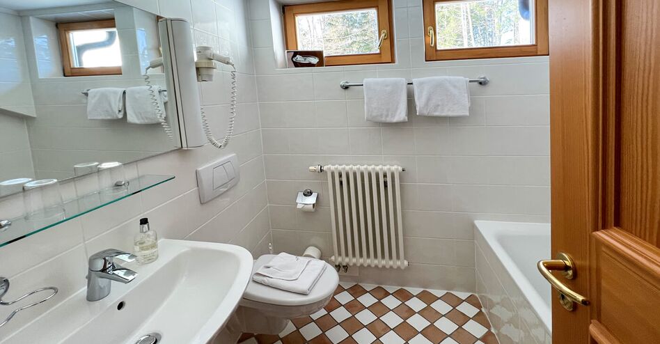 Berghotel Sudelfeld Bayrischzell Doppelzimmer hier das Badezimmer, Waschbecken, Toilette Badewanne Boden mit braun weissen Fliesen